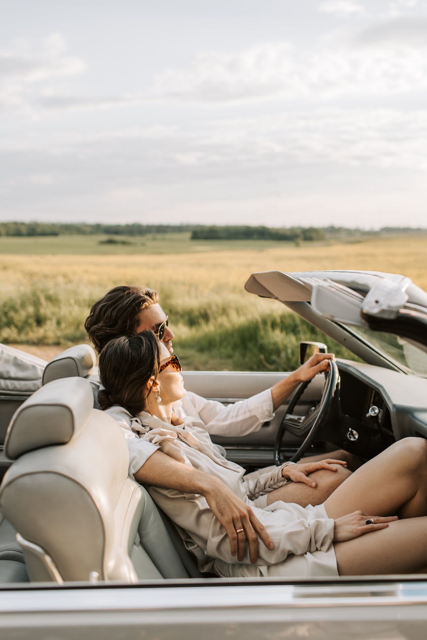a romantic couple sitting on the car